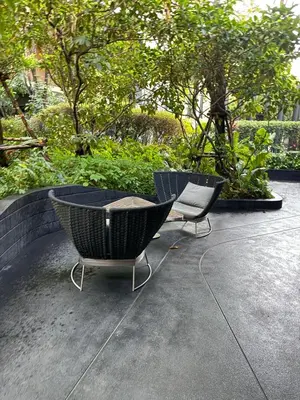 two chairs and a table on a patio with trees at City Heaven - Coowork - Gym - BTS - Pool - Mall - Starbucks - ShoppingMall in Bangkok