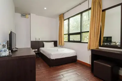 a bedroom with a bed and a desk and window at Collection O Khaosan Park in Bangkok
