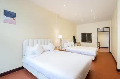 two beds in a hotel room with white sheets at OH Homes - Samsen 10 in Bangkok