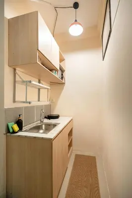 a kitchen with wooden cabinets and a sink at OH Homes - Samsen 12 in Bangkok