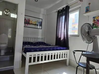 a bedroom with a bed and a window and a fan at Jatujak Bangkok guesthouse R5 in Sathani Bang Su