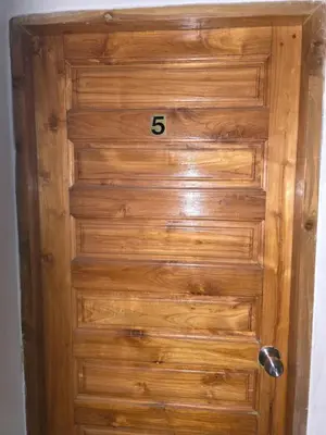 a wooden door with the number on it at Jatujak Bangkok guesthouse R5 in Sathani Bang Su