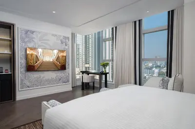 a bedroom with a white bed and a large window at La Clef Bangkok by The Crest Collection in Bangkok
