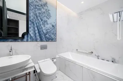 a white bathroom with a sink and a toilet at La Clef Bangkok by The Crest Collection in Bangkok
