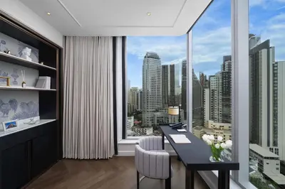 a dining room with a table and a large window at La Clef Bangkok by The Crest Collection in Bangkok