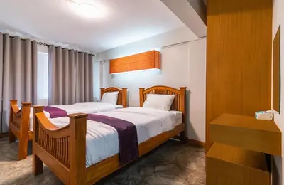 a bedroom with two beds and a desk in it at XX GO INN Khaosan ตรอกข้าวสาร สนามหลวง in Bangkok