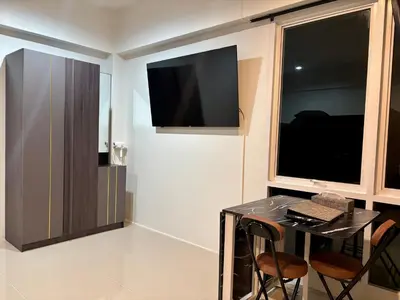 a room with a table and a television on the wall at โรงพักบางระมาด by ModiCoff Café in Sathani Ban Chim Phali