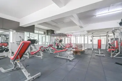 a gym with red chairs and machines in a room at AC Habitat Bangkok in Bangkok