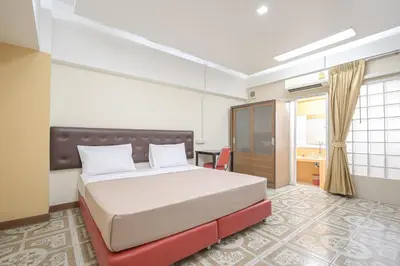 a bedroom with a large bed and a desk at AC Habitat Bangkok in Bangkok