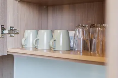 a row of mugs and glasses on a shelf at loft \u6cf3\u6c60\u516c\u5bd3 \u4e09\u623f\u4e8c\u536b \u514d\u8d39WiFi in Bangkok