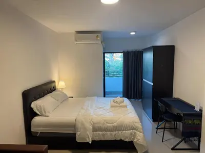 a bedroom with a bed and a desk and a window at ณัฐพิมลเพลส์ 3 in Bangkok Yai