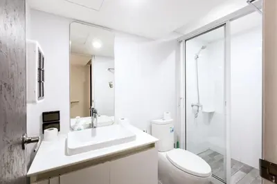 a white bathroom with a toilet and a sink at 24 degree hotel & hostels in Bangkok