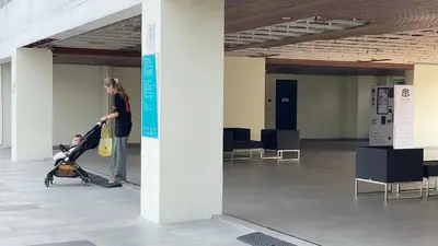 a woman pushing a child in a stroller in a building at \u66fc\u8c37\u7e41\u534e\u5730\u533a\u516c\u5bd3 \u514d\u8d39\u4e0a\u7f51 \u5bb6\u5c45\u5bb6\u7535\u9f50\u5168 in Bangkok