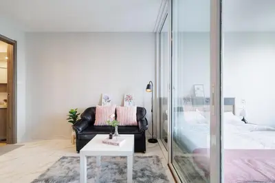 a living room with a black leather chair and a table at \u66fc\u8c37\u7e41\u534e\u5730\u533a\u516c\u5bd3 \u514d\u8d39\u4e0a\u7f51 \u5bb6\u5c45\u5bb6\u7535\u9f50\u5168 in Bangkok