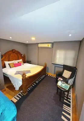 a bedroom with a bed and a chair in it at Bangkok Thailand Core Business District 3b3b Duplex Private House Family Room Cooking Smoking Nursery in Bangkok