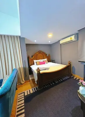a bedroom with a bed and a blue couch at Bangkok Thailand Core Business District 3b3b Duplex Private House Family Room Cooking Smoking Nursery in Bangkok
