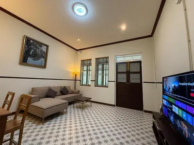 a living room with a couch and a flat screen tv at Luan Heritage Surawong in Bangkok