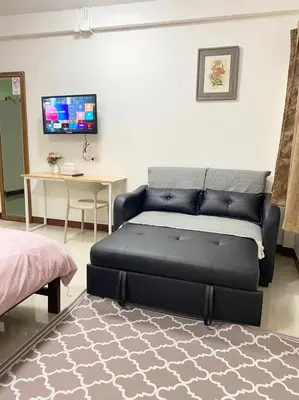 a living room with a bed and a table at La Maison 230 in Ban Khlong Samrong