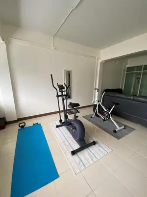 a gym with two exercise bikes and a couch at Homey Place in Ban Song Hong