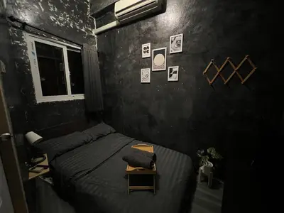 a bedroom with two beds and a table in it at Stay Strays Hostel in Bangkok