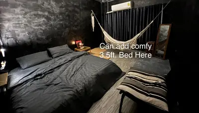 a bedroom with a bed and a hammock in it at Stay Strays Hostel in Bangkok