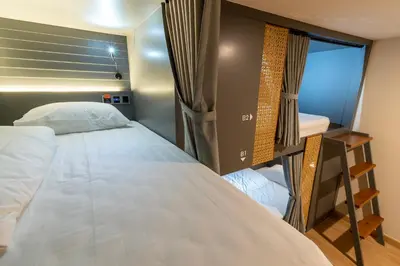a small bedroom with a bed and a window at The Chedee Krungthep in Bangkok