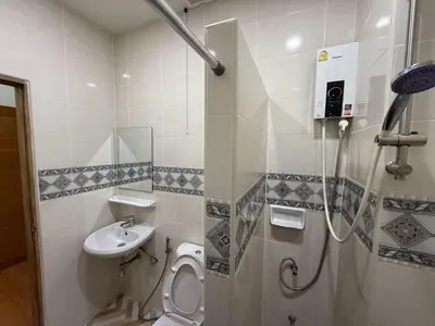 a bathroom with a toilet and a sink at The Burapa Rooms in Bangkok
