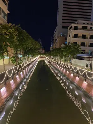 a bridge over a river in a city at night at The Burapa Rooms in Bangkok
