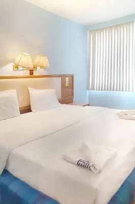 a hotel room with two beds with a towel on the bed at xx Wish Inn Chidlom - วิช อินน์ ชิดลม ราชดำริ 2 in Pratunam