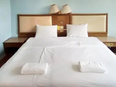 a large white bed with two white towels on it at xx Wish Inn Chidlom - วิช อินน์ ชิดลม ราชดำริ 2 in Pratunam