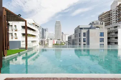 a large swimming pool in a city with buildings at 2 Bedrooms, Downtown BKK, BTSAsok, Sukhumvit in Bangkok