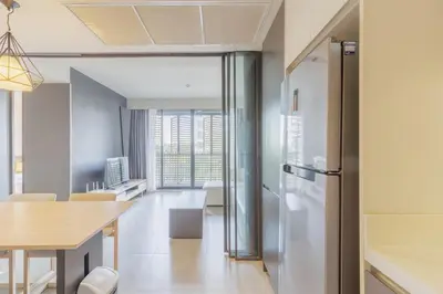 a kitchen with a refrigerator and a dining table at 2 Bedrooms, Downtown BKK, BTSAsok, Sukhumvit in Bangkok