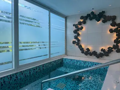a swimming pool in a building with a window at Luxurious High-Rise - Ultra Fast Wifi - MRT Petchaburi in Bangkok