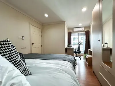 a bedroom with a bed and a desk and a window at Upscale Expansive 2BR - Ultra Fast Wifi - Phrom Phong in Bangkok