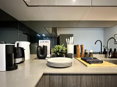 a kitchen with a counter top with plates and utensils at Expansive Stylish 2BR - Ultra Fast Wifi - Asoke in Bangkok