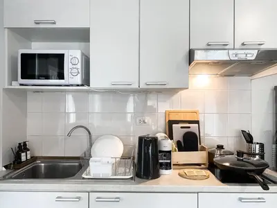 a kitchen with white cabinets and a sink at Exclusive Urban Apt 1BR - Ultra Fast Wifi - Thong Lo in Bangkok