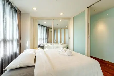 a bedroom with two beds and a large mirror at 2Br, Good view, BTS Chitlom, BKK in Bangkok