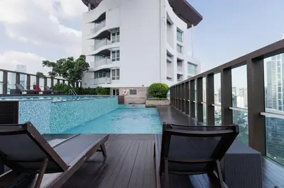 a balcony with a swimming pool and two chairs at Large room with 2Beds BTS Chitlom Sukhumvit BKK in Bangkok
