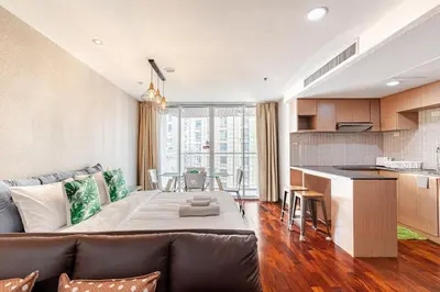 a living room with a couch and a kitchen at Large room with 2Beds BTS Chitlom Sukhumvit BKK in Bangkok