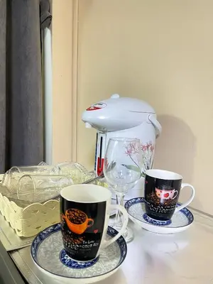 two coffee cups and a blender on a counter at Ordinary Salaya in Sathani Sala Ya