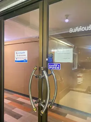 a revolving door in a building with a sign on it at Ordinary Salaya in Sathani Sala Ya