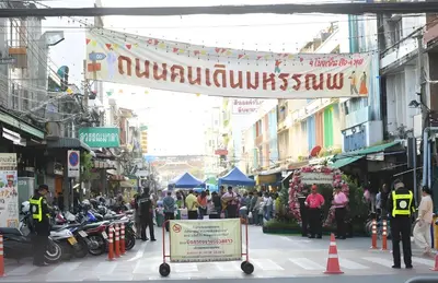a crowd of people walking down a busy city street at xx GO INN The Giant Swing เสาชิงช้า กรุงเทพ in Bangkok