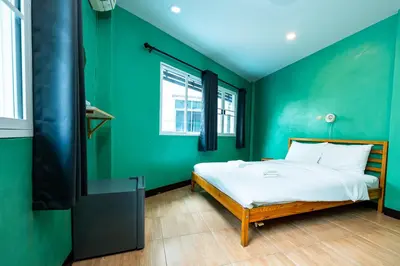 a green bedroom with a bed and a tv at xx GO INN The Giant Swing เสาชิงช้า กรุงเทพ in Bangkok