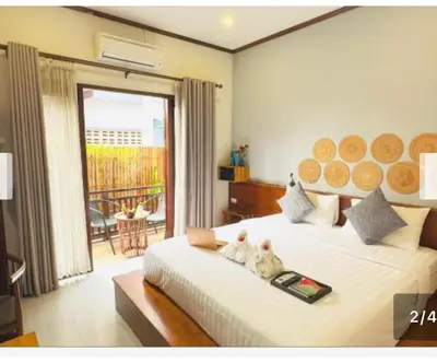 a bedroom with a bed with two cats sitting on it at Laung Prabang museum inn& travel in Bang Su
