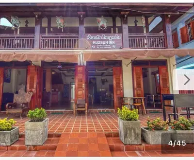 a building with tables and chairs in front of it at Laung Prabang museum inn& travel in Bang Su