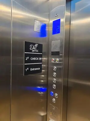 a metal elevator with a sign on it at Diff Apartel Banglamphu in Bangkok