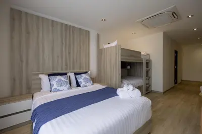 a bedroom with a large bed with blue and white pillows at Diff Apartel Banglamphu in Bangkok