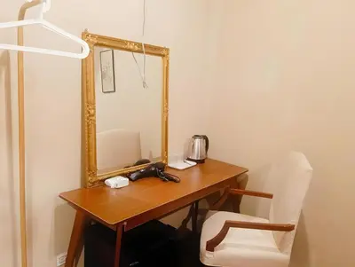 a wooden table with a mirror and a chair at Rest Inn China Town - Yaowarat BKK in Samphanthawong