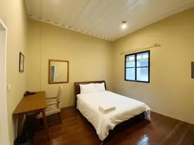 a bedroom with a bed and a desk and a window at Rest Inn China Town - Yaowarat BKK in Samphanthawong