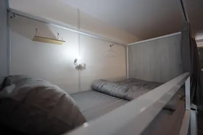 a small room with a bed in the corner at Risa Hostel - Female Only for Solo Travelers in Bangkok